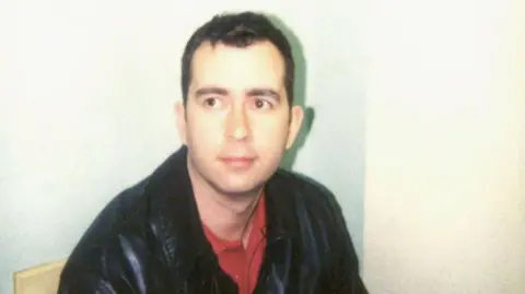 Getty Images A Metropolitan police photo of Robert Hendy-Freegard wearing a leather jacket and red t-shirt in 2005