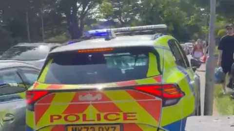 Julie Swift A police car struggles to pass parked cars on a gridlocked road in Formby.