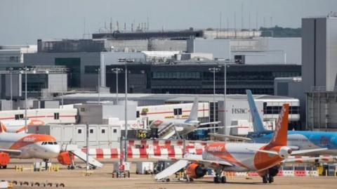 Several planes on a runway at Gatwick Airport