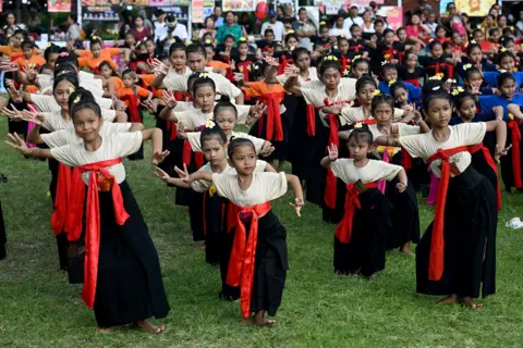 Children perform a traditional Balinese dance to release the sunshine of 2025 and welcome the sunshine of 2026 during a New Year's Eve celebration in Denpasar, Bali, Indonesia, on December 31, 2025.