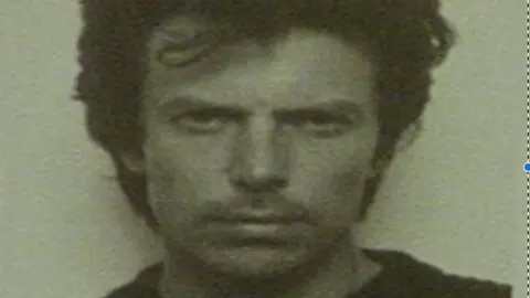 Mug shot of Robin Boswell taken in 1983. He had thick dark hair and wears a dark jumper.