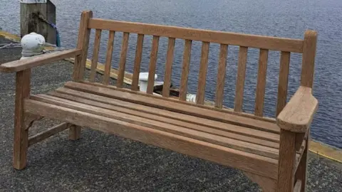Windermere Lake Cruises A solidly-made wooden bench on a pier near a lake.