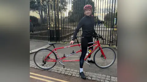 Greg James Greg James sat on tandem bike in London