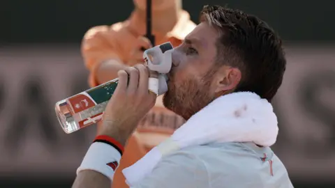Cameron Norrie takes a drink of water