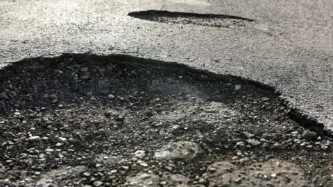 Getty Images Large pothole in road