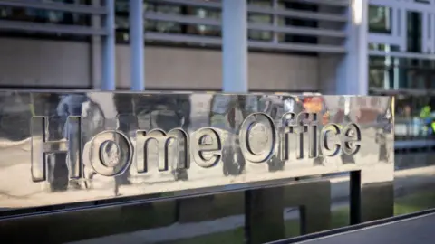 A rectangular metal sign which reads 'Home Office'