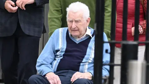 Alan Lewis/Photopress An elderly man with white hair in a wheelchair wearing a navy and blue striped jumper