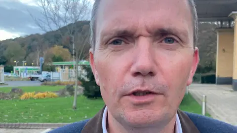 Councillor Mike Bell wearing a white shirt and blue blazer