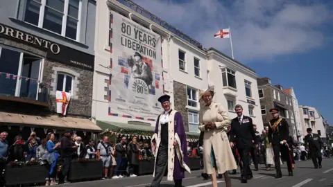 The Princess Royal, accompanied by Vice Admiral Sir Tim Laurence (second row, right), during a visit to St Peter Port, as they attend commemorations in Guernsey 