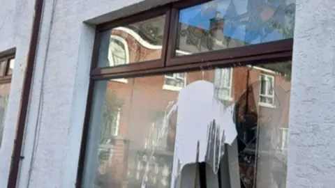 A white house with pain on the window