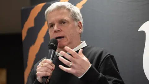 Lance Bradley speaking with a microphone