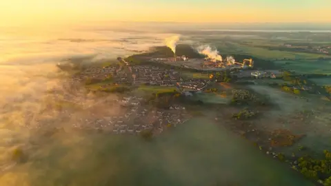 Kevin Hamill A drone shot taken far above the village of Cowie. It appears to be early in the morning and mist covers part of the town.