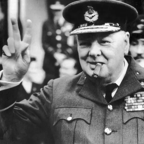 Getty Images Winston Churchill, wearing an RAF uniform, with cigar in mouth, does his characteristic V for victory salute