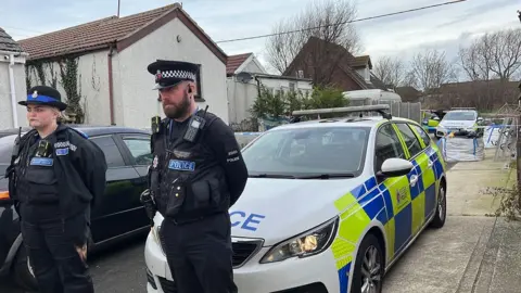 Richard Knights/BBC Police officers guard a cordon in Hillman Avenue, Jaywick