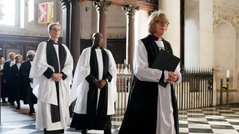 PA Media Dame Sarah leads a line of clergy up the aisle at St Paul's