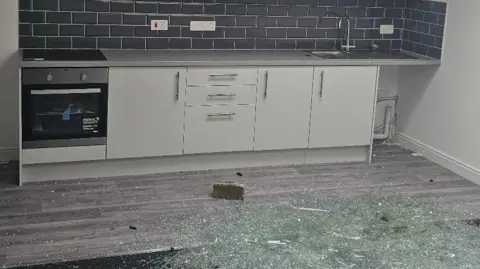 RSPCA Broken glass and brick on floor of Ramsgate kitchen flat