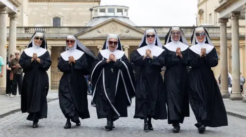 Anna Barclay Members of the cast of Sister Act walk in a line through the centre of Bath near the Theatre Royal