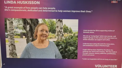 Linda Huskisson A purple Make a difference poster with Linda's picture on it.