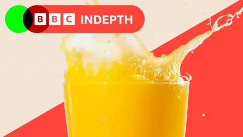 A glass of orange juice with a splash