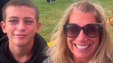 Family handout A blonde woman with sunglasses smiling with her teenage son.