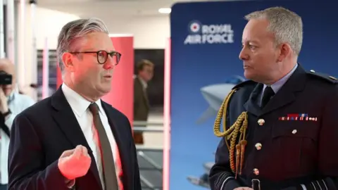PA Media Prime Minister Sir Keir Starmer (left) speaks with Air Chief Marshal Richard Knighton (second right) during a visit to a defence contractor in Bedfordshire