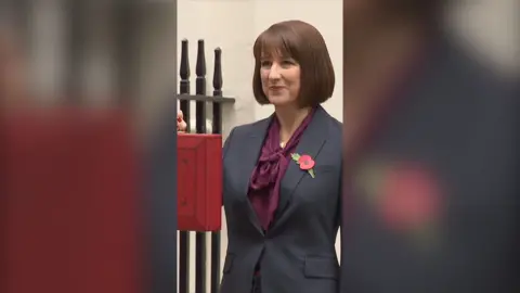 Rachel Reeves wearing burgundy blouse and grey blazer