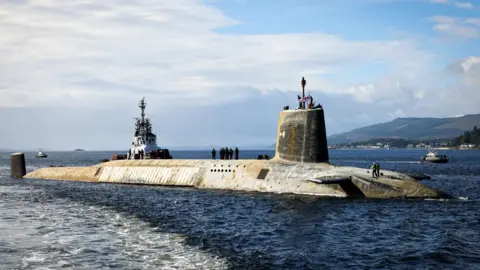 Royal Navy A shot of a Vanguard submarine half submerged in the water. 