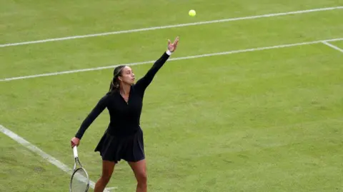 Getty Images A picture of tennis player Eden Silva in a black outfit throwing a tennis ball up in the air 
