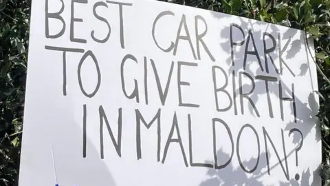 Hayley Edwards A protest sign at St Peter's Hospital in Maldon, which reads: "Best car park to give birth in Maldon?"