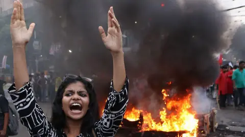 Getty Images 2024 年 6 月 25 日，在印度加尔各答，一名活动人士在抗议 NEET 和 UGC-NET 考试最近发生的骗局期间，正在抗议并焚烧肖像和轮胎，并封锁道路。 