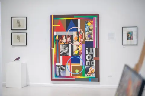 Courtesy of the Phillips family A brightly coloured art piece by Peter Phillips sits in a gallery with smaller pieces of art surrounding it