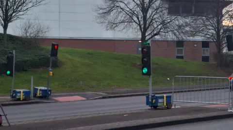 Sandwell Council Two traffic lights are positioned either side of the main road enabling people to cross the main road