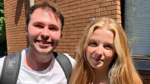 A male university student and a female university student standing next to each other.