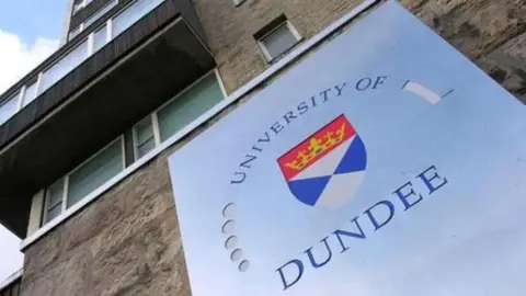 Značka čtení University of Dundee připojená k kamenné budově