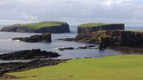 A series of small islands and coastal arches on Papa Stour