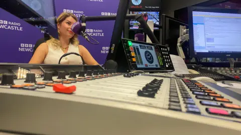 Kim McGuinness sitting opposite the presenter's desk at BBC Radio Newcastle