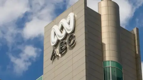 Building with ABC logo against a blue sky background with some white clouds