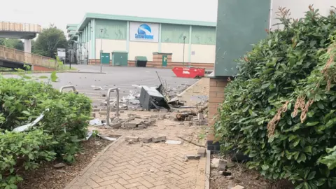 Rubble scattered on a pavement outside the hotel 