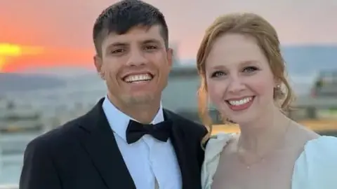 Facebook A wedding photo showing a man in an evening suit and a woman in a wedding dress, smiling.
