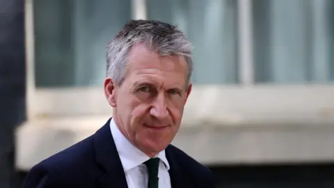 Andy Rain/EPA/Shutterstock Headshot of Jarvis who looks into the camera. He is outside but he background is blurry. He wears a suit and tie and has greying hair 