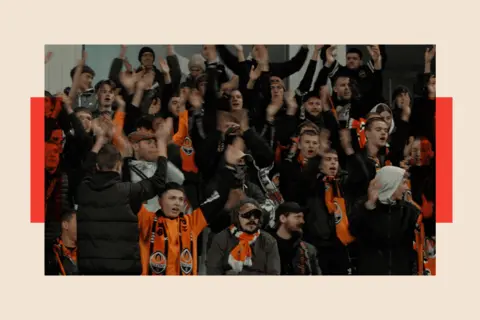 Stuart Phillips/BBC People cheering at the football game
