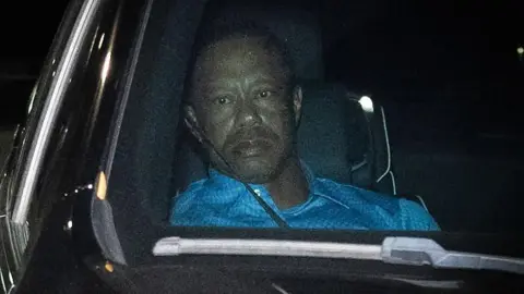 Tiger Woods sits in a car after being arrested in Florida 