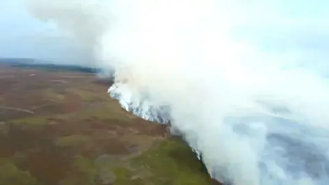North Yorkshire Fire Service/PA Wire Smoke rises into the sky above burning moorland