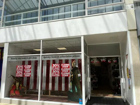 A shop front with 'closing down' posters