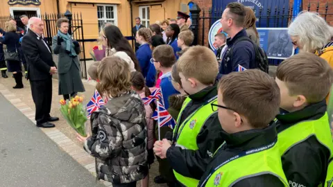 BBC/Damian O'Neil Princess Anne meets a small group of schoolchildren who are waving UK flags and hold flowers