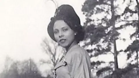 A black and white picture of Andrée Blouin wearing a hat