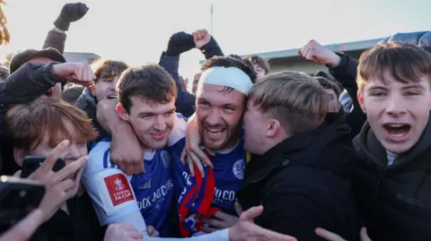 Paul Dawson of Macclesfield celebrates with team-mate Luke Duffy and fans after the team's victory over Crystal Palace