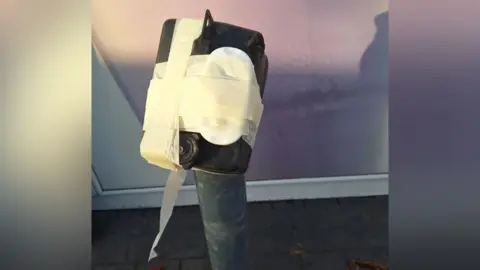 Northumbria Police A black box taped to a bollard. A white device is under the tape, which looks to be a small clock.