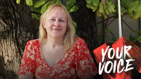 Andrea Pendry on holiday in the Maldives wearing a red and white floral dress. The photo is stamped with Your Voice branding