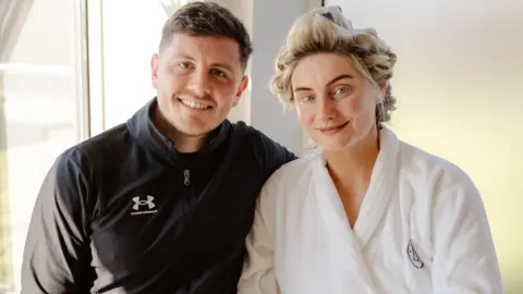 fed0b8a0-5340-11f1-bbfe-9d39384b3a85.jpg Bride weds in dressing gown, slippers and rollers as 'it's what married life is like'